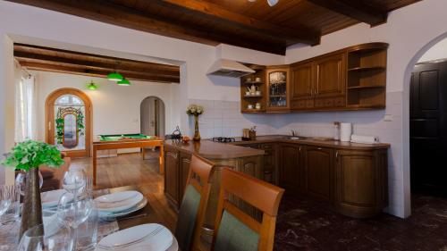 eine Küche mit Holzschränken und einem Esstisch in der Unterkunft VacationClub - Cicha 8 Apartament 1 in Polanica-Zdrój