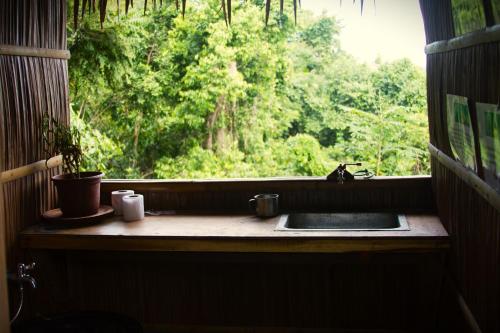 ein Fenster mit einem Waschbecken und Waldblick in der Unterkunft The Overlook in San Vicente