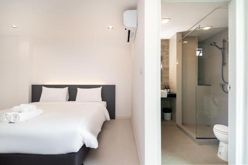 a bedroom with a bed and a bathroom with a shower at The Urban Oasis in Bangkok