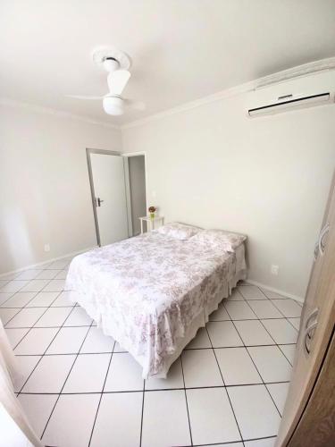 1 dormitorio con 1 cama en una habitación blanca en Apto 2 Quartos, pertíssimo da Beira-Mar e Ponte HL, en Florianópolis