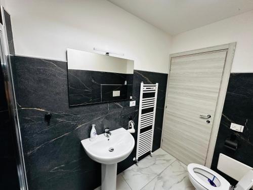 a black and white bathroom with a sink and a toilet at La casa verde in Beccacivetta