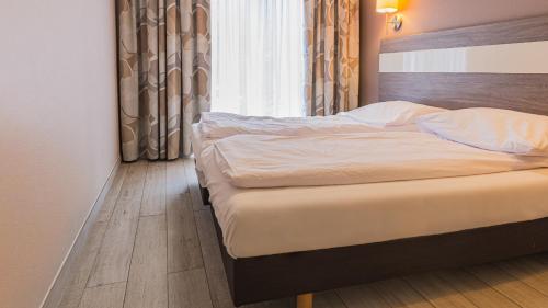 1 cama en un dormitorio con ventana en VacationClub - TIGNES Apartament 6, en Sienna