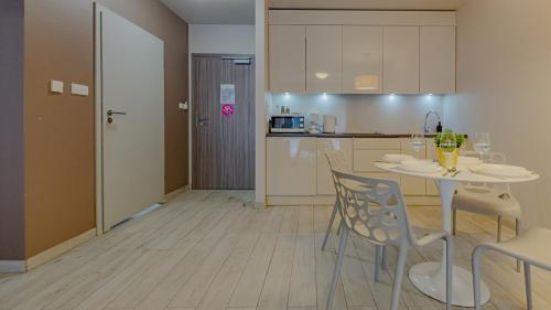cocina y comedor con mesa y sillas en VacationClub - TIGNES Apartament 6, en Sienna