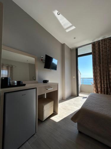 a hotel room with a bed and a large window at Endless Blue Himara in Himare