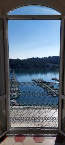 a window view of a harbor with boats in the water at La Terrazza sulla baia di Le Grazie in Portovenere