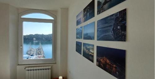a room with pictures on the wall and a window at La Terrazza sulla baia di Le Grazie in Portovenere