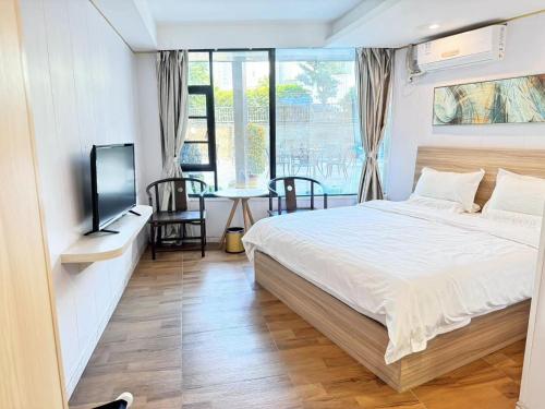 a bedroom with a bed and a tv and a table at Zhuhai Dreamers Capsule Hotel in Zhuhai