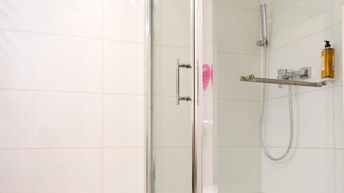 uma casa de banho com um chuveiro e uma porta de vidro em VacationClub - STUBAI Apartament 19 em Sienna