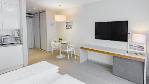 uma cozinha com um balcão com uma televisão e uma mesa em VacationClub - STUBAI Apartament 19 em Sienna
