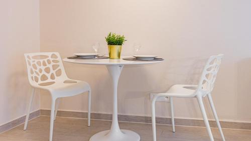 uma mesa branca com duas cadeiras e uma mesa com copos em VacationClub - STUBAI Apartament 19 em Sienna