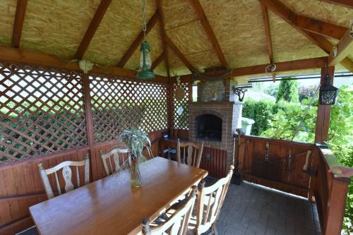 an outdoor dining room with a table and a fireplace at Vyšnia in Zarasai