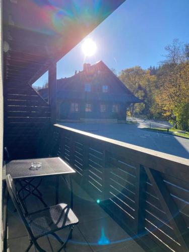 a patio with a table and a chair on a balcony at Apartmány NETA Velké Karlovice, Polanský Dvůr in Velké Karlovice
