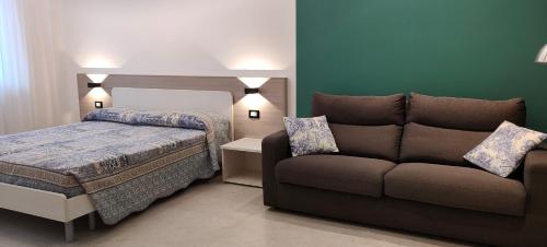 um quarto com uma cama e um sofá em Casa Mariettina em Sottomarina