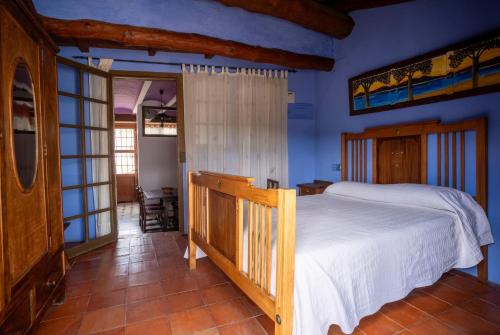 a bedroom with a bed and blue walls at Casa Rural Aldaba in Alcalá del Júcar