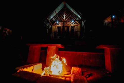 a fire pit in front of a house at night at The Rainforest Hideaway in Deniyaya