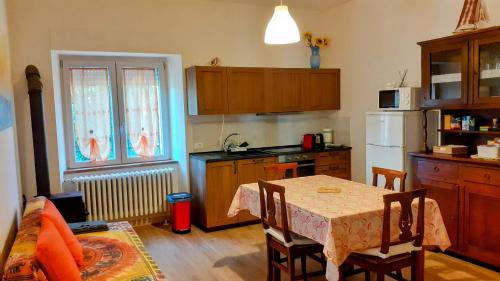 a kitchen with a table and a kitchen with a refrigerator at Casa Vitiolo 