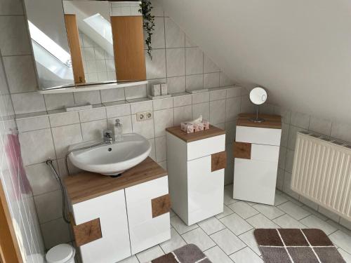 a bathroom with a sink and a mirror at Noras Ferienwohnung 