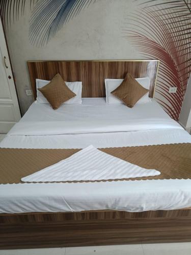 ein Bett mit weißer Bettwäsche und Kissen darauf in der Unterkunft Royal stay in Dehradun
