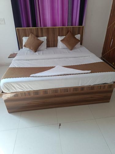 ein großes Bett mit einem Holzrahmen in einem Schlafzimmer in der Unterkunft Royal stay in Dehradun
