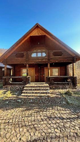 a log cabin with stairs in front of it at Moonglade Allure Houses in Polyana