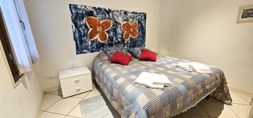 ein Schlafzimmer mit einem Bett mit roten Kissen darauf in der Unterkunft Andry Apartment with private Garden in Lido di Venezia