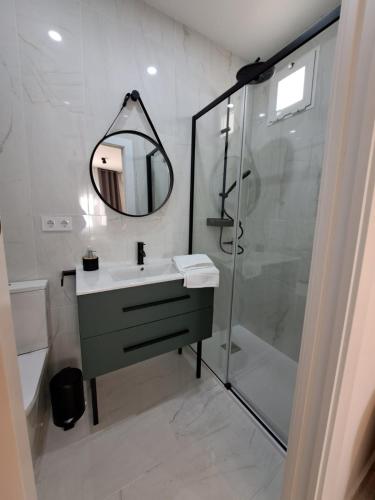 a bathroom with a sink and a shower with a mirror at VIVAL RASTRO DELUXE in Úbeda