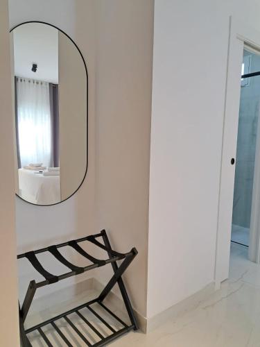 a mirror on a wall next to a chair at VIVAL RASTRO DELUXE in Úbeda