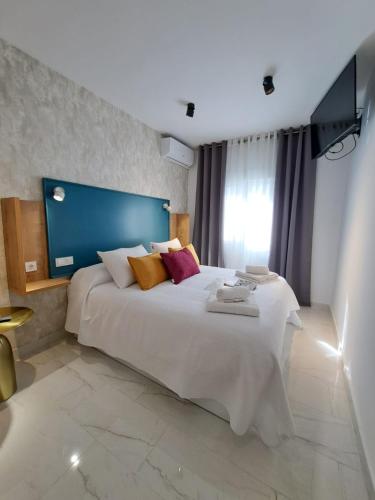 a bedroom with a large white bed with pillows at VIVAL RASTRO DELUXE in Úbeda