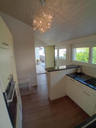 a kitchen with a chandelier and a counter top at Wohnresidenz Casa Fortuna in Suhr
