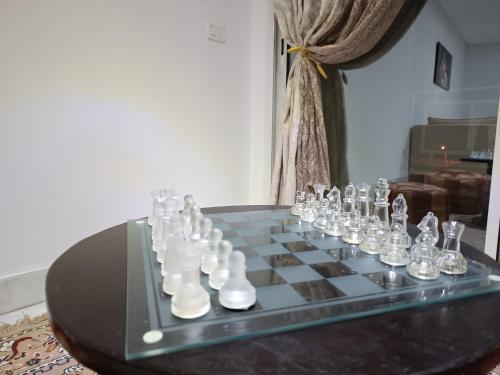 a chess board with glass chess pieces on a table at appartement S+2, proche plage in Monastir