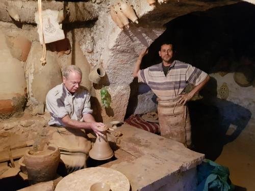 two men are making pottery on a table at Dar Aladin in Arkou