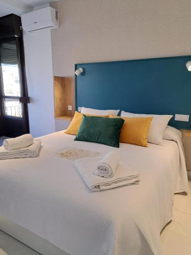 a large white bed with two towels on it at VIVAL RASTRO DELUXE in Úbeda