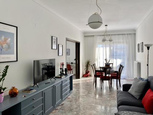 een woonkamer met een bank, een tv en een tafel bij Serene Apartment with Breathtaking Sea View in Thessaloniki