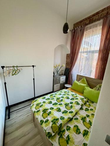 a bedroom with a bed with a yellow and green quilt at Saules Apartament in Daugavpils