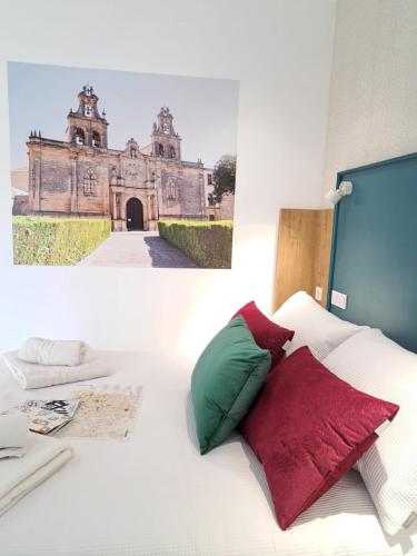 a bed with two pillows and a picture of a building at VIVAL RASTRO DELUXE in Úbeda