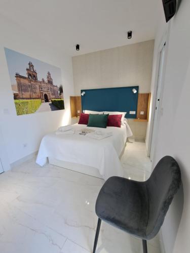 a bedroom with a bed and a chair in it at VIVAL RASTRO DELUXE in Úbeda