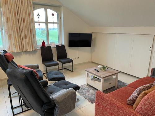 a living room with a couch and chairs and a tv at Deichkrone-Rees in Rees