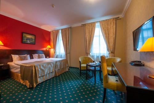 una camera d'albergo con letto e scrivania di Hotel Europa a Poprad