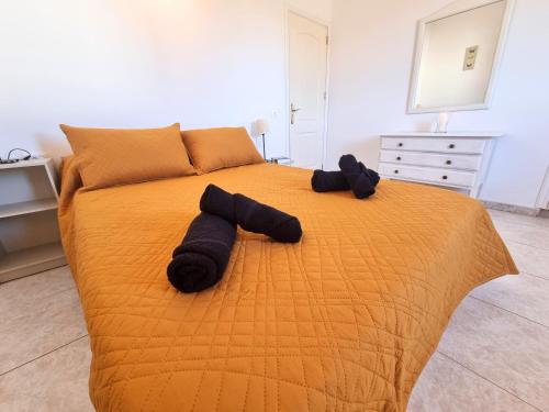 - un lit avec 2 serviettes noires dans l'établissement Diadas home, à Guargacho