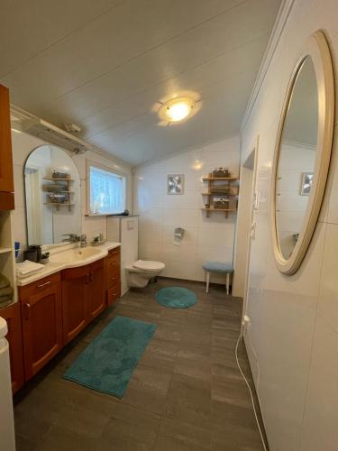 a bathroom with a sink and a toilet and a mirror at Cozy home in Godfjord in Sortland