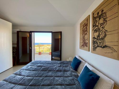 a bedroom with a large bed with blue pillows at Penthouse Le Isole - Luxury rooftop retreat in Marsala