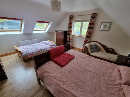 a bedroom with two beds and a couch at Glencolmcille Spectacular Views in Glencolumbkille