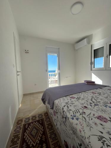 a bedroom with a bed with a view of the ocean at Villa Marina in Dobra Voda