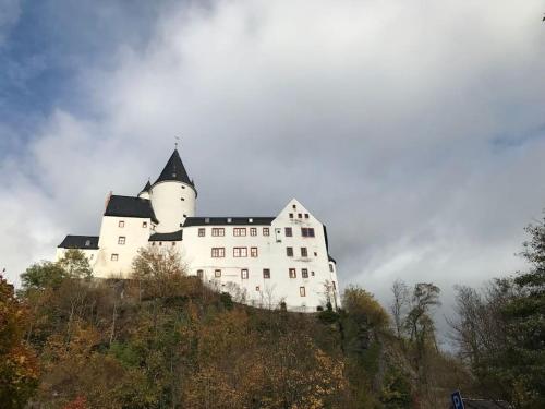 a large white castle on top of a hill at Villa Schloßblick-Schwarzenberg in Neuanbau