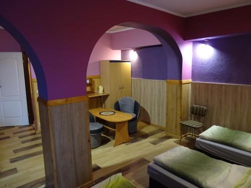 a room with purple walls and a table and a bed at GOŚCINIEC AGROZAJAZD in Głuchołazy