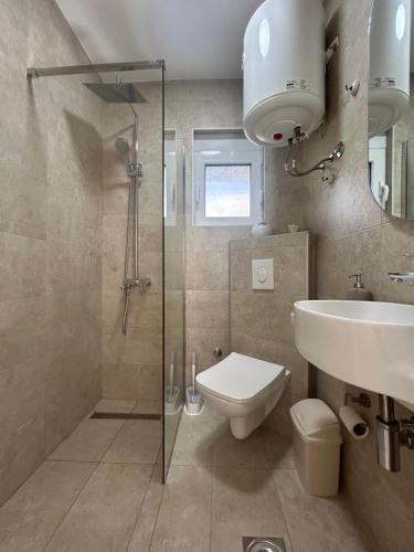 a bathroom with a shower and a toilet and a sink at Villa Marina in Dobra Voda