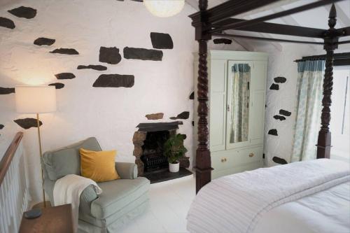 a bedroom with a bed and a fireplace at Bluebell cottage in Ulverston