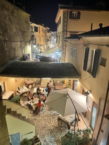 a group of people sitting under an umbrella on a street at La Fortezza in Capoliveri
