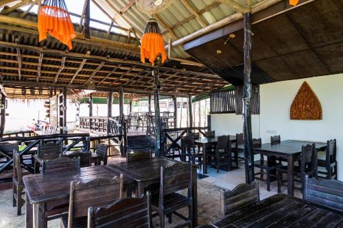 een leeg restaurant met houten tafels en stoelen bij Mook Lanta Eco Resort in Koh Lanta