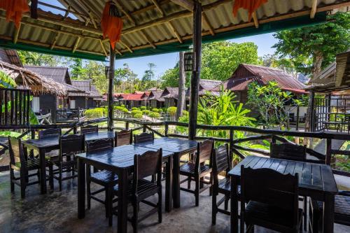 een groep tafels en stoelen in een restaurant bij Mook Lanta Eco Resort in Koh Lanta